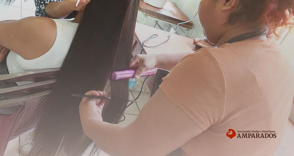 Una de las viudas practicando un peinado en los talleres